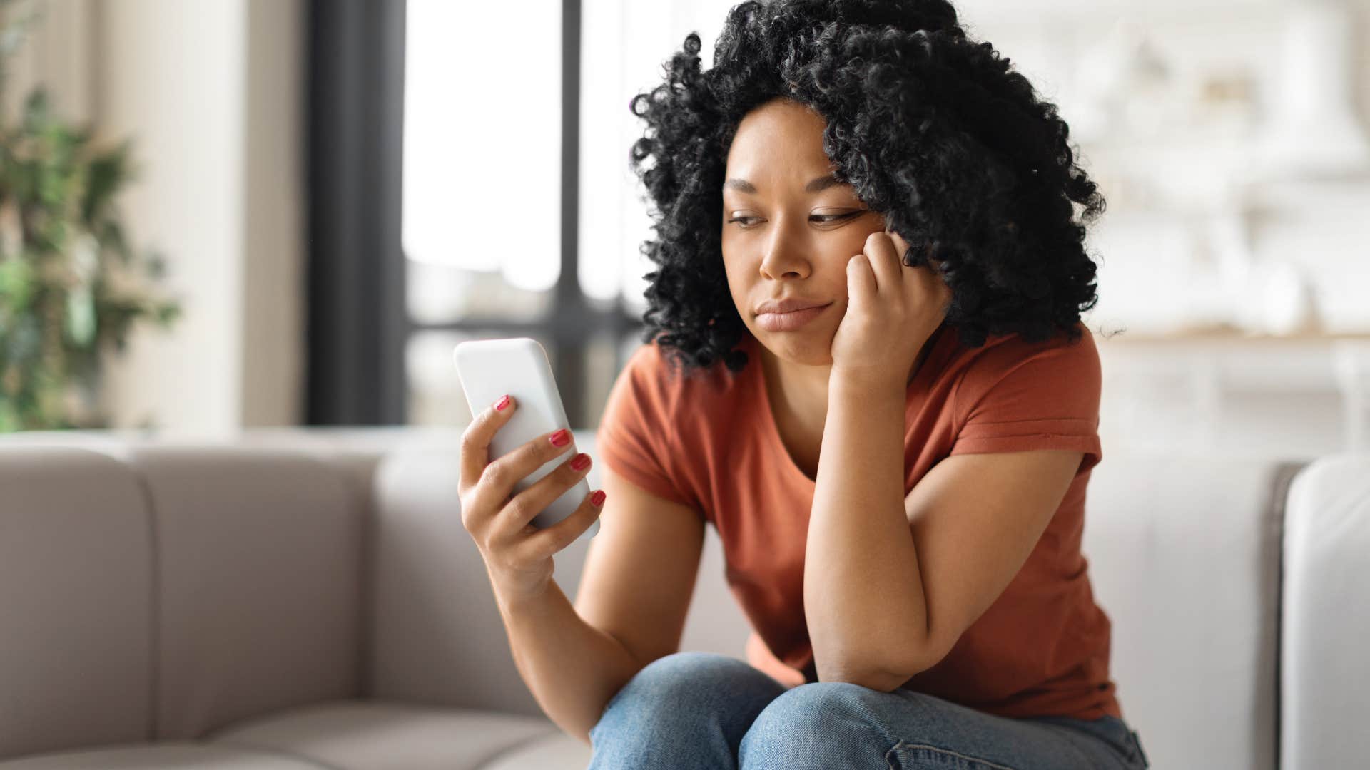 sad woman looking at her phone