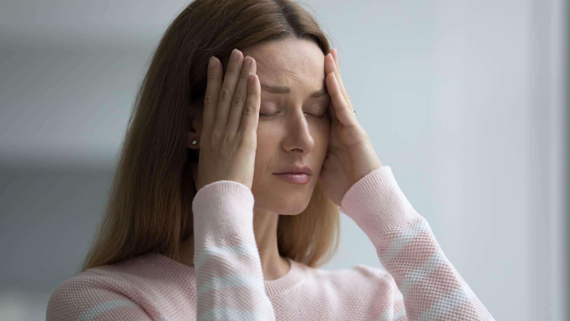 upset stressed woman holding her temples