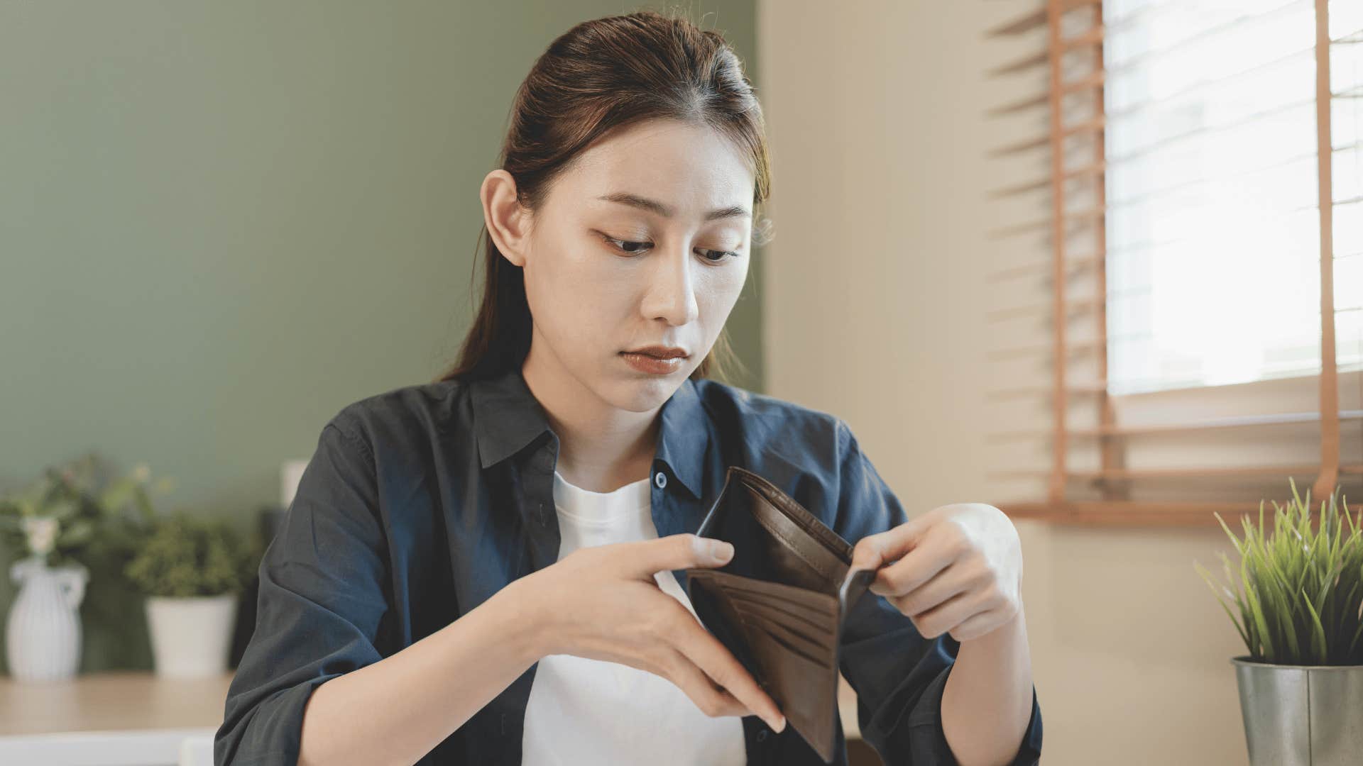 Gen Z woman looking at her empty wallet