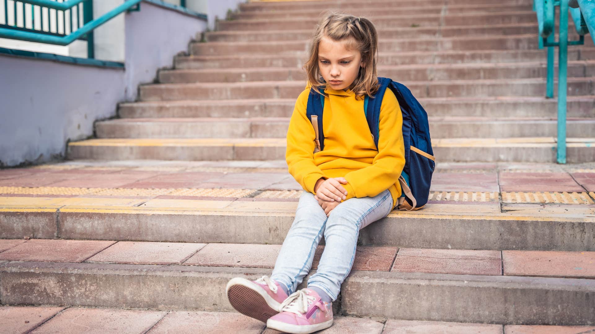 little girl all alone sitting outside