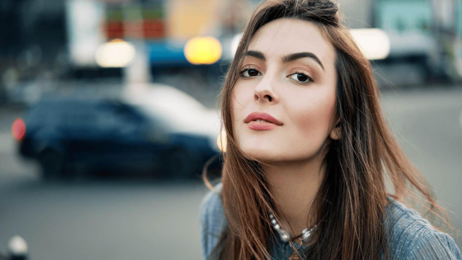 Close up young beautiful woman portrait posing in the city street in summer