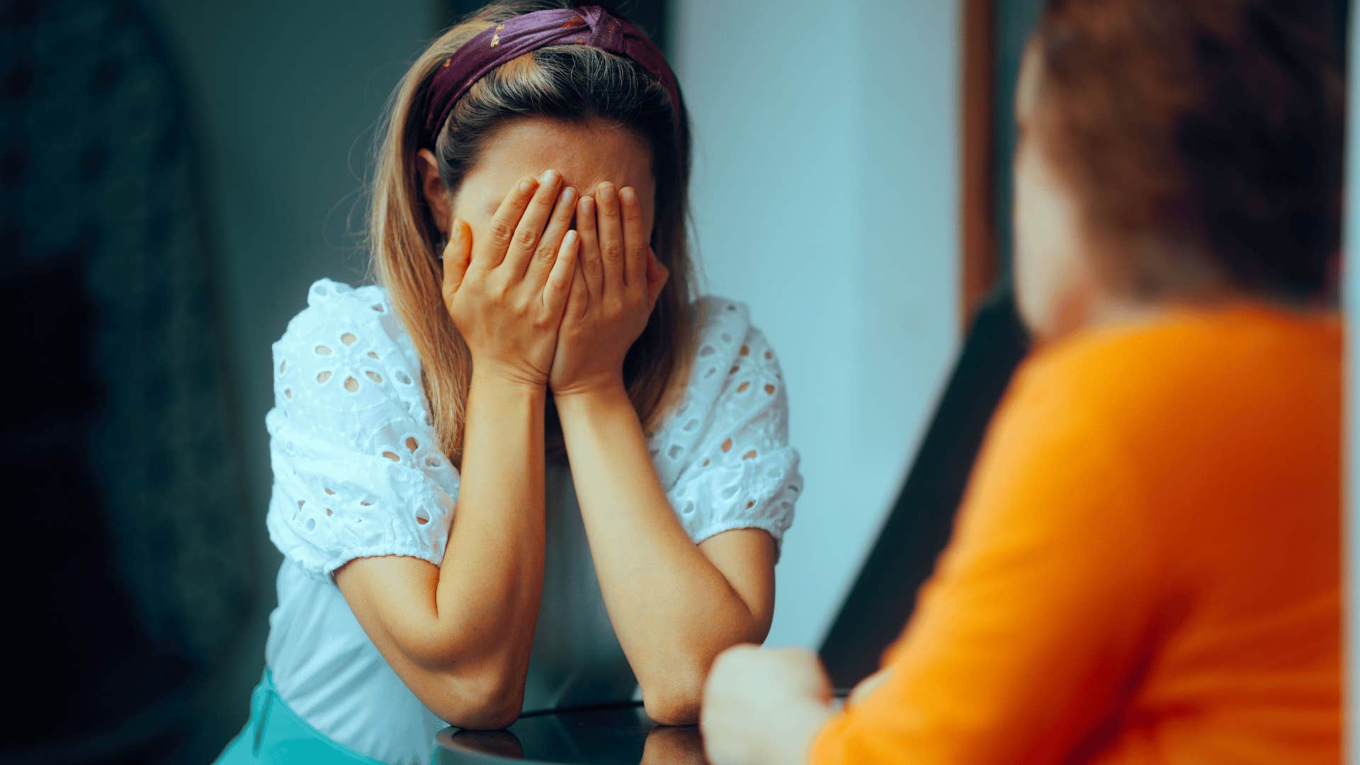 woman crying with head in her hands