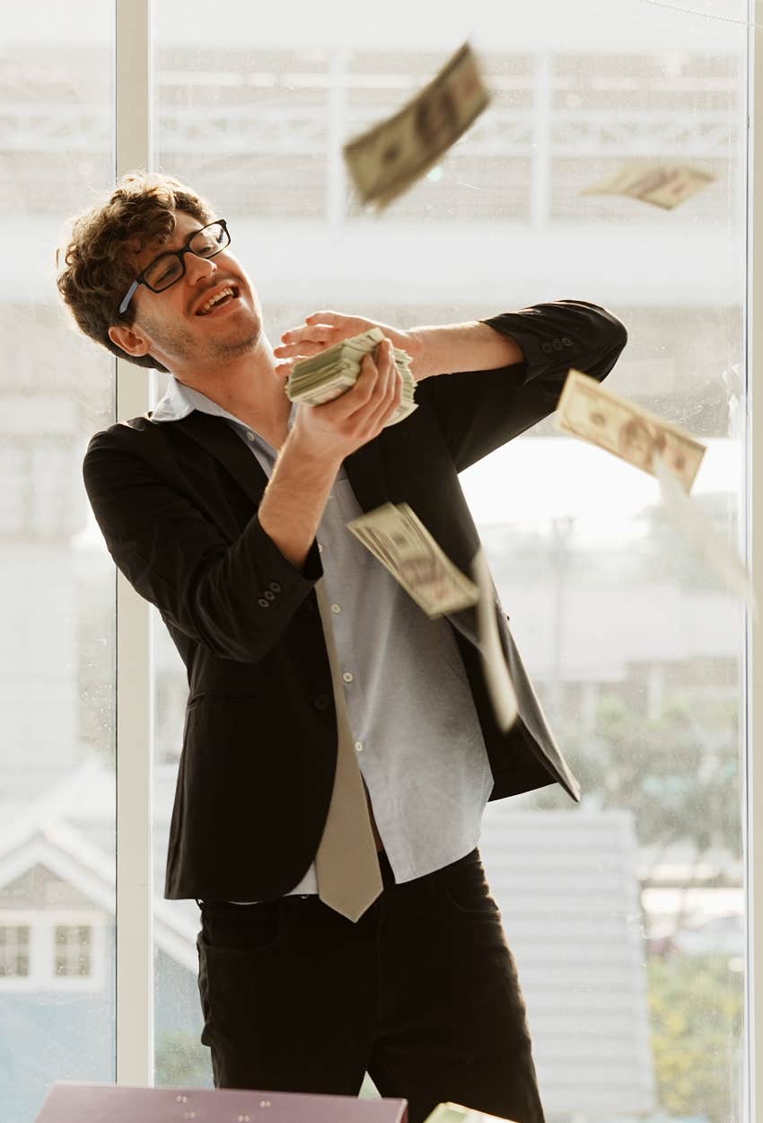 man throwing money born on 18th 19th destined financial success