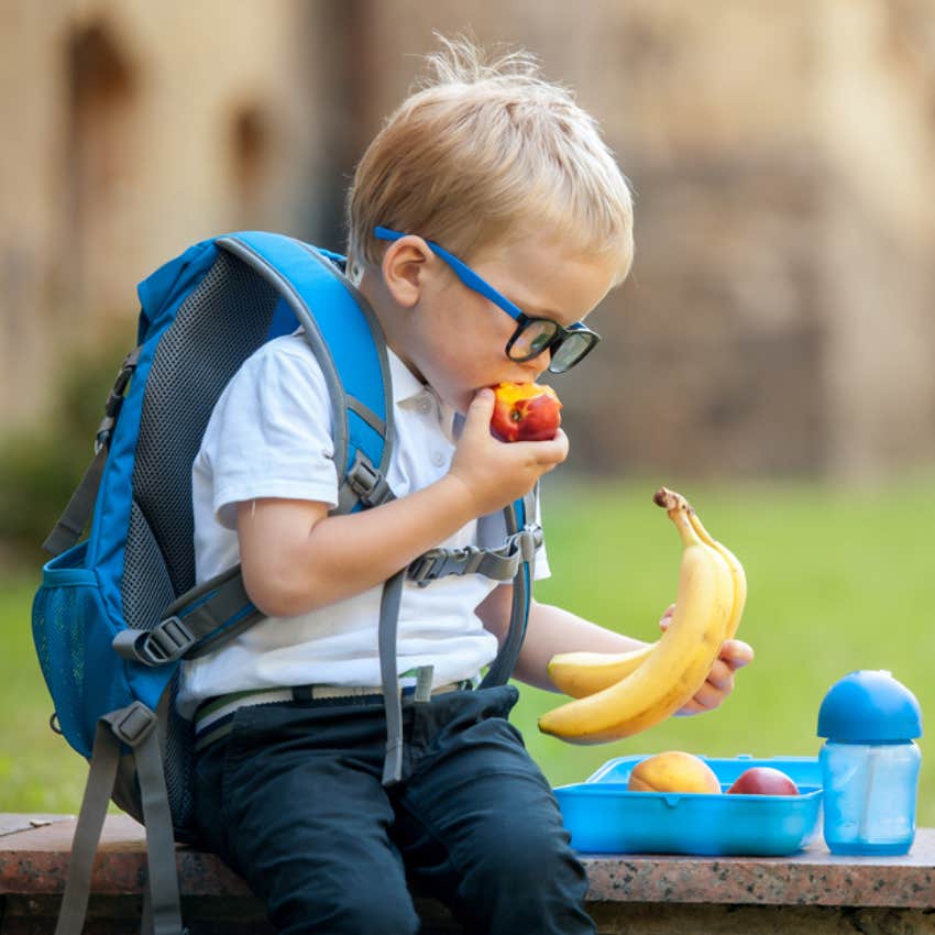 little boy eating fruit at school