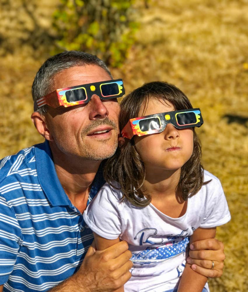 father and daughter looking at the eclipse