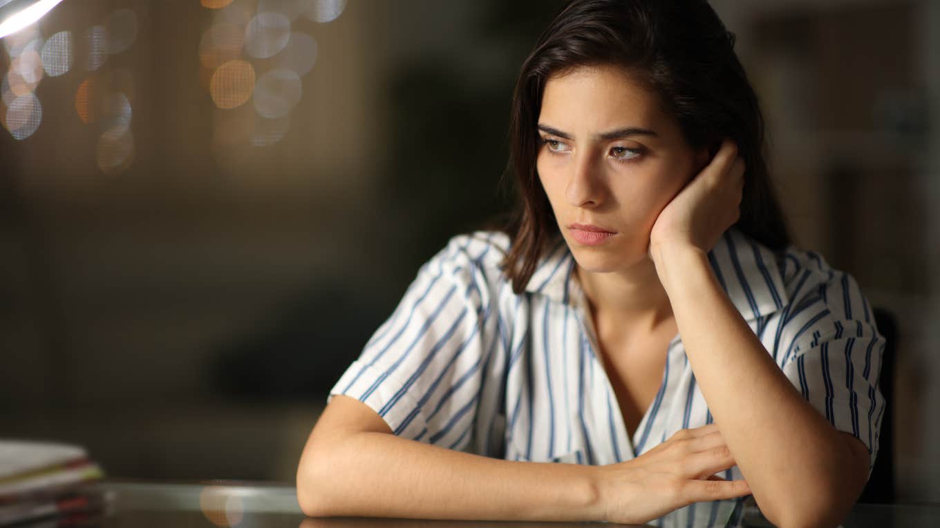 A woman looking contemplative, representing the signs of someone who was chronically invalidated as a child and how it affects them in adulthood