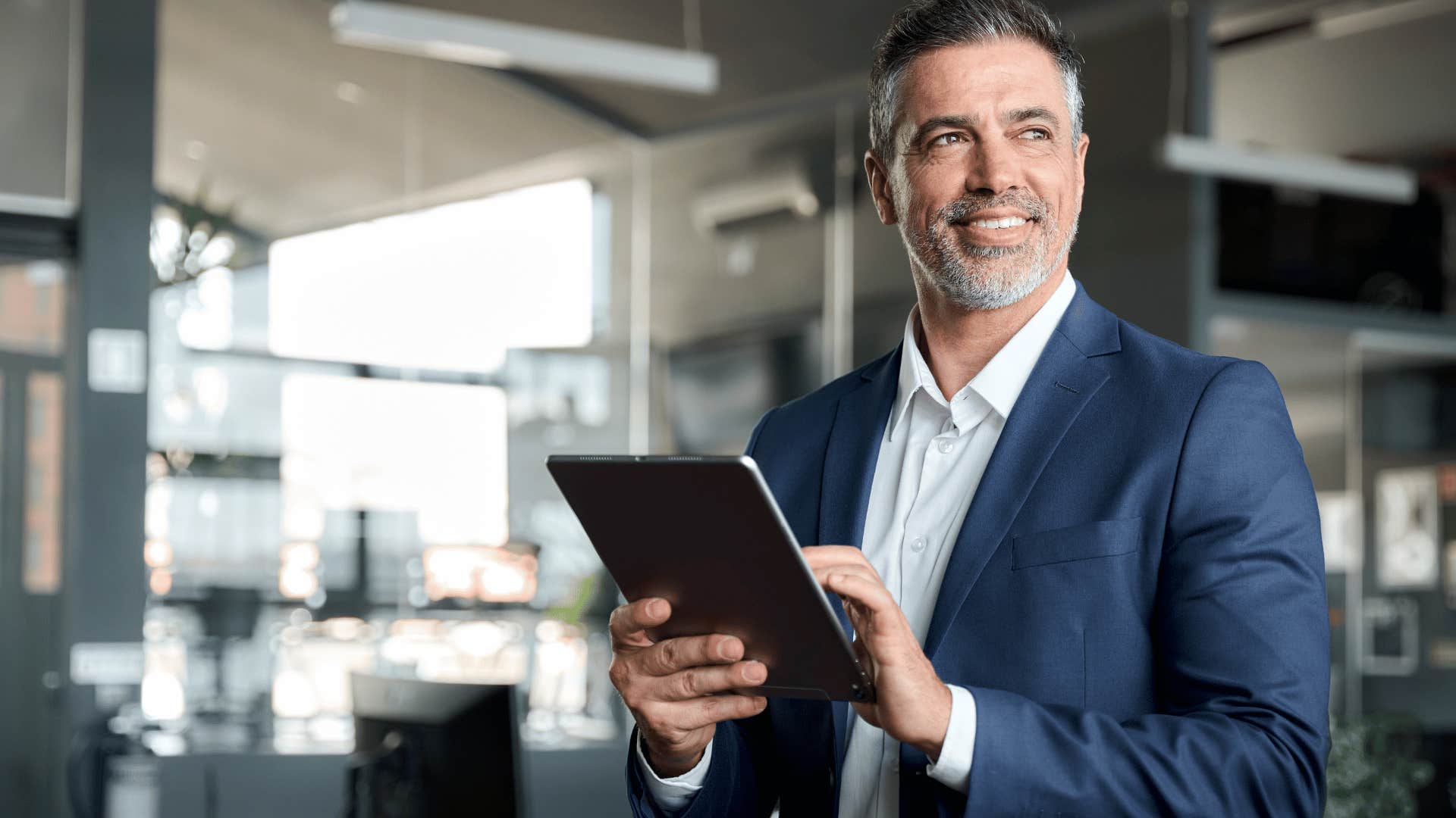 man smiling holding tablet