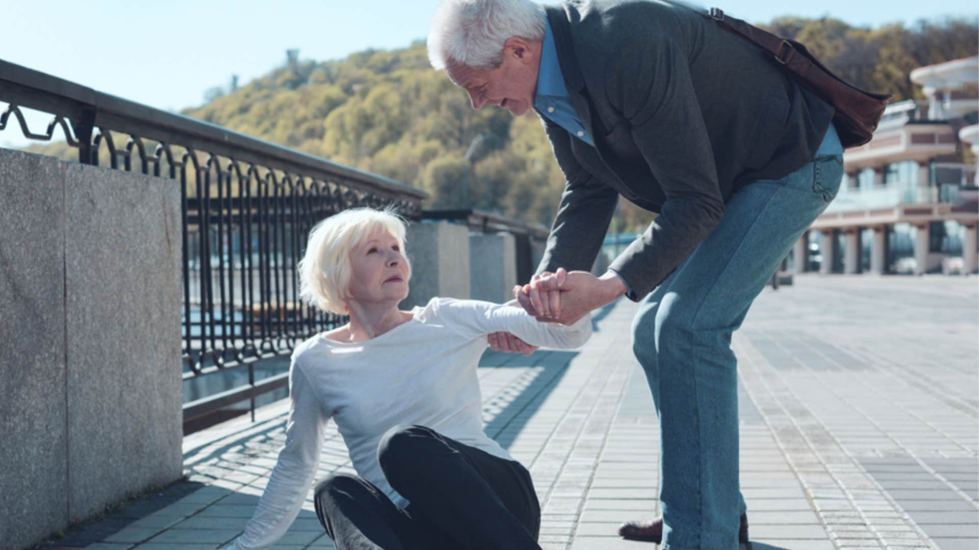 man helping woman up 