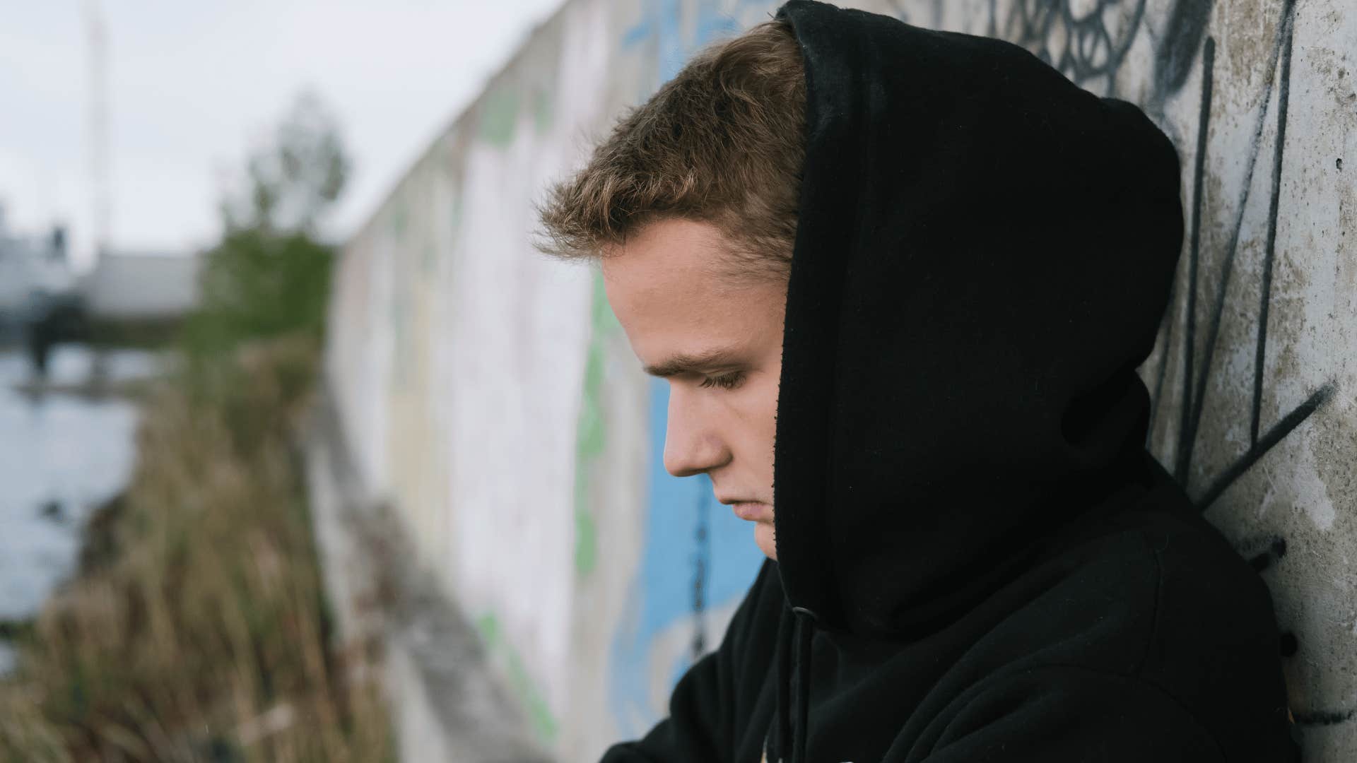 sad young man sitting outside