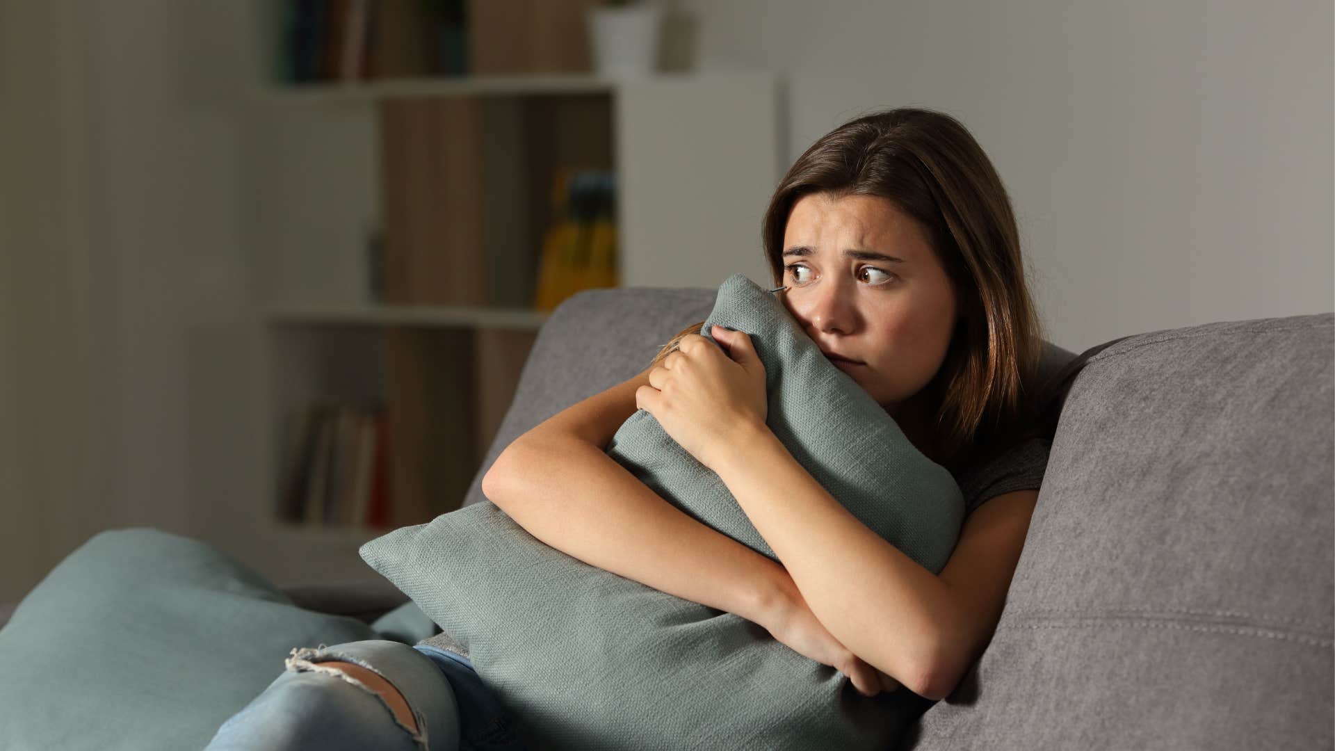 young woman hiding on her couch