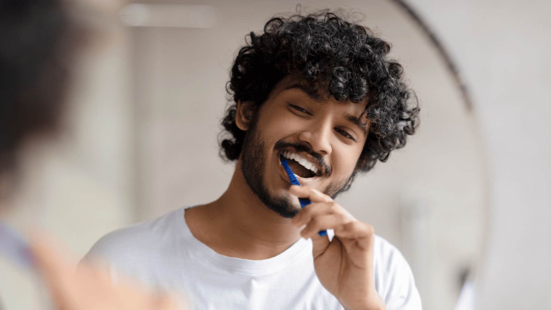 man brushing teeth thinking about positive life changes