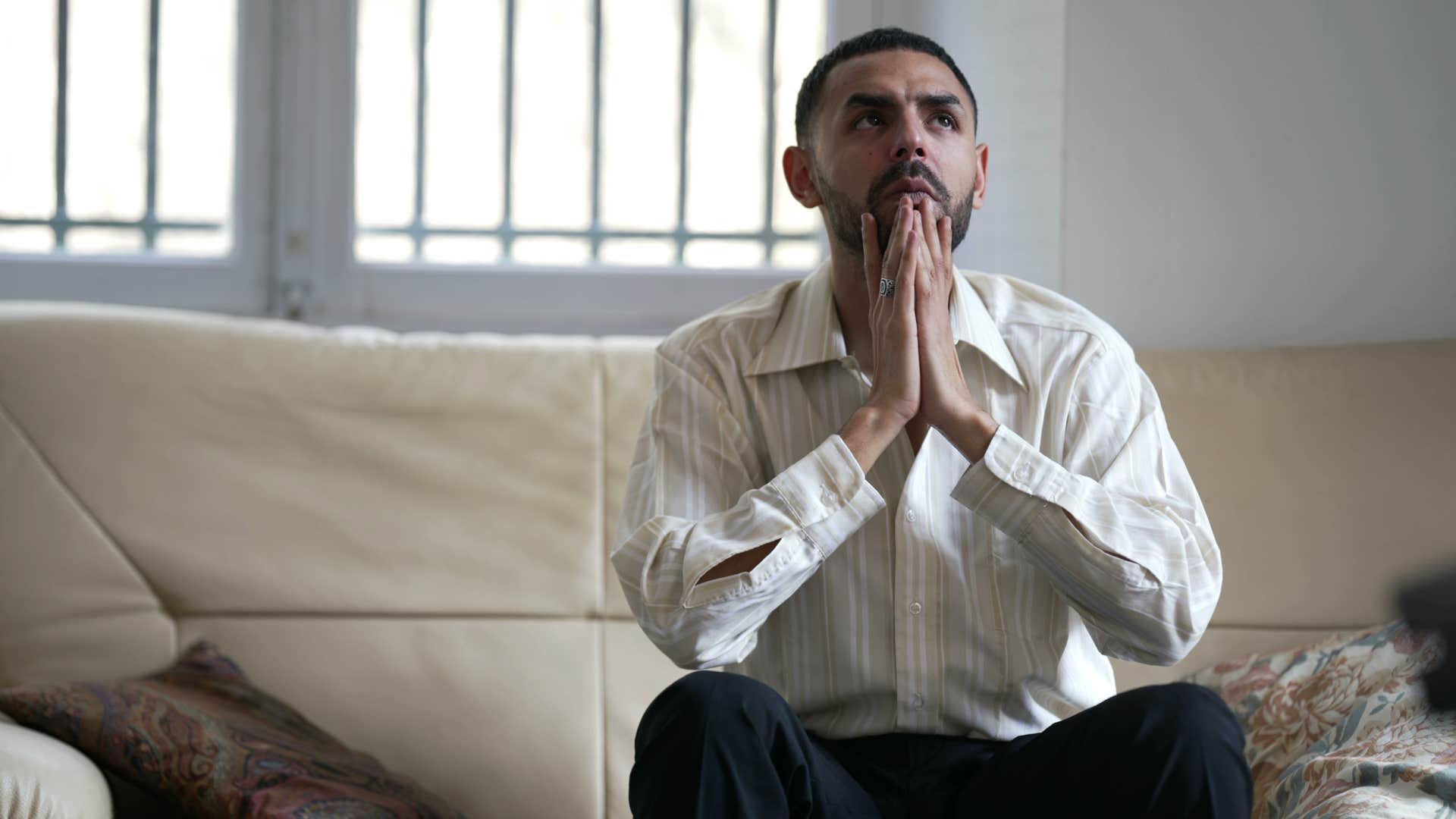 man feeling hopeless sitting on couch at home