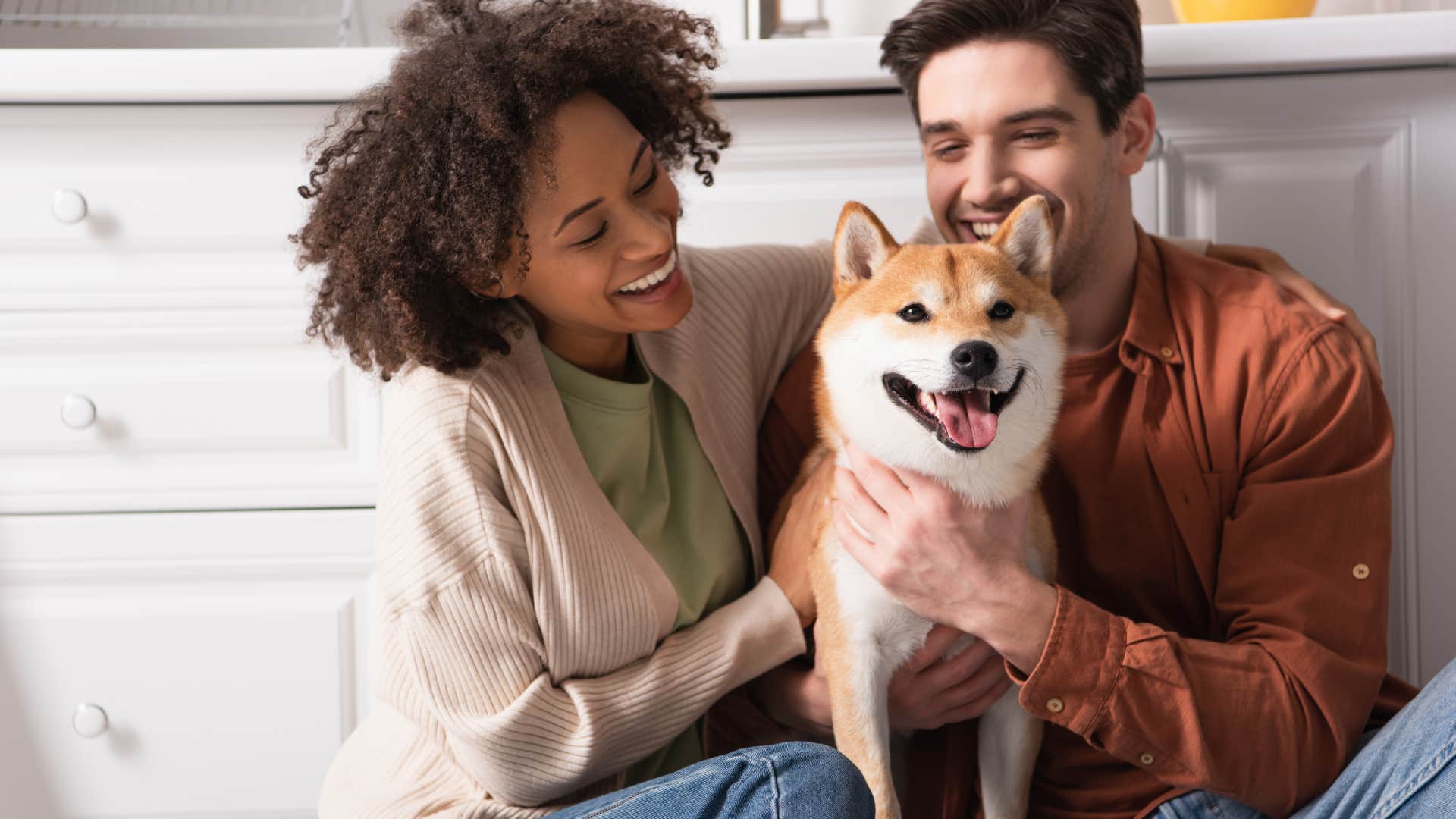 couple sitting with dog on floor