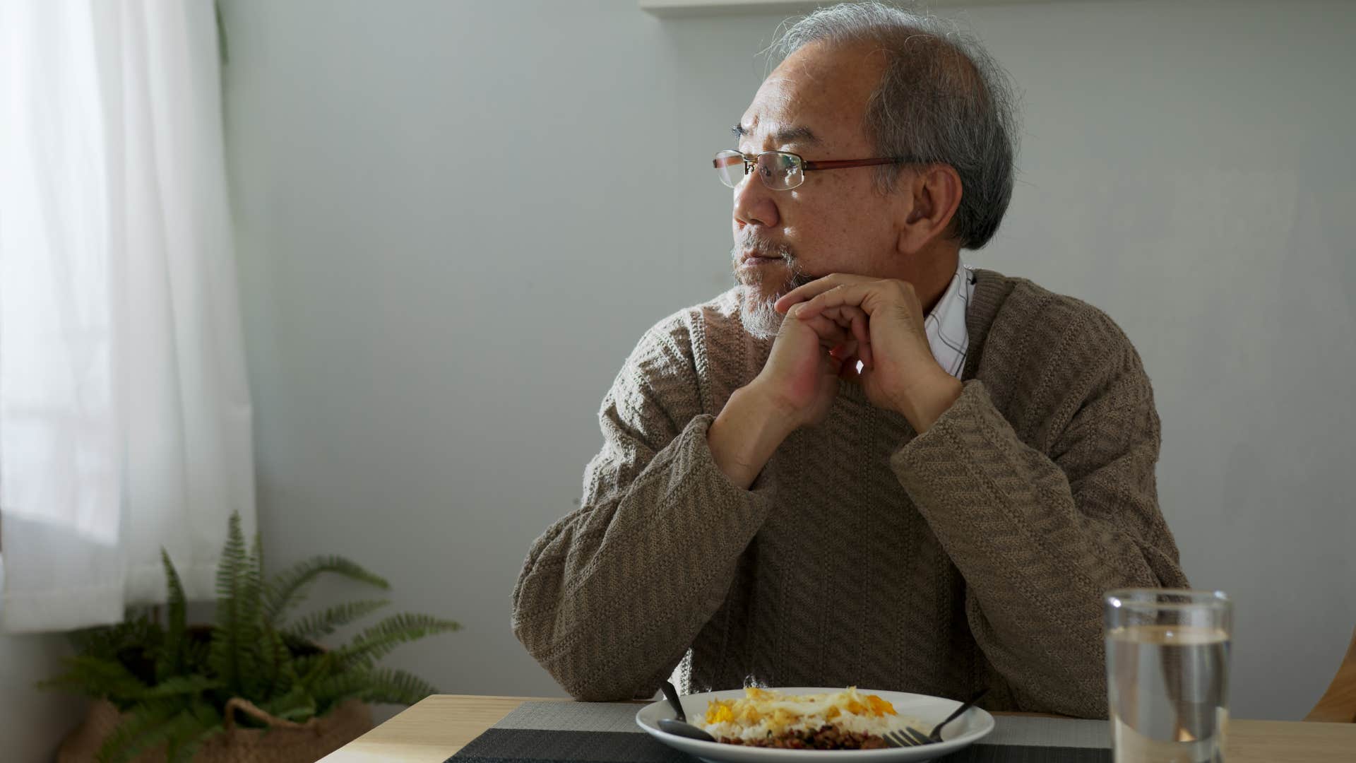 sad man sitting in front of food