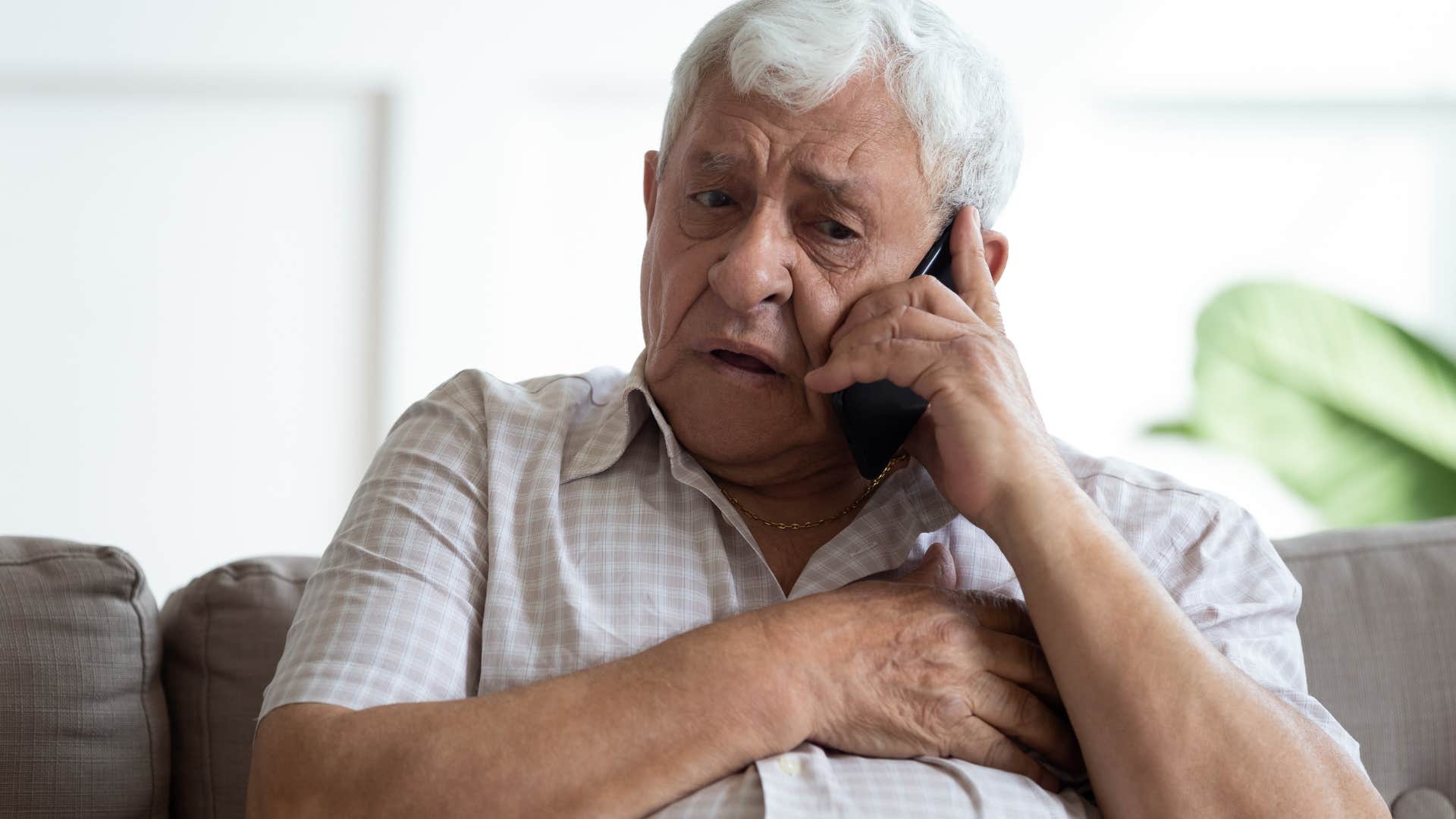 older man looking upset talking on the phone