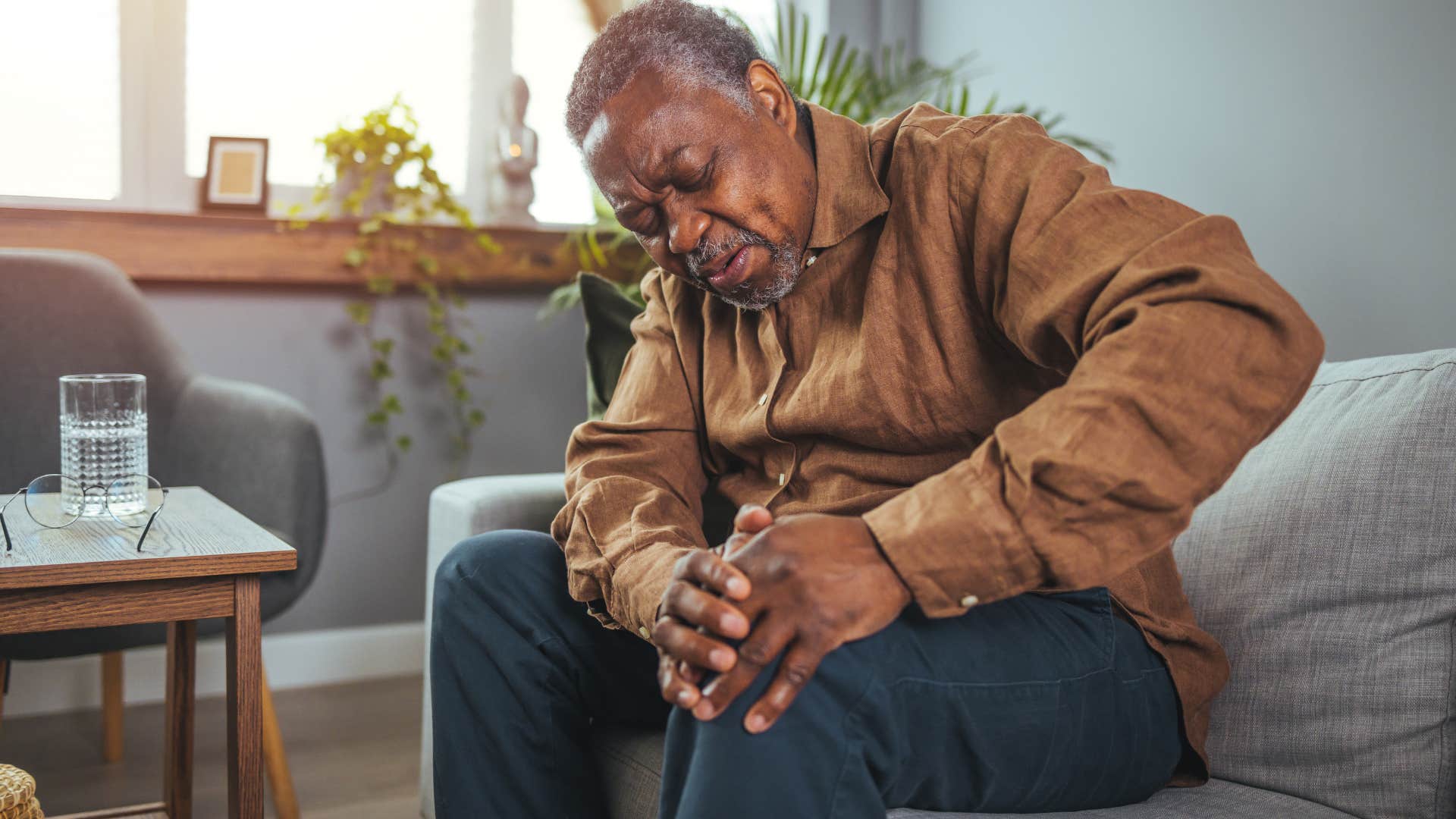 older man holding his injured knee