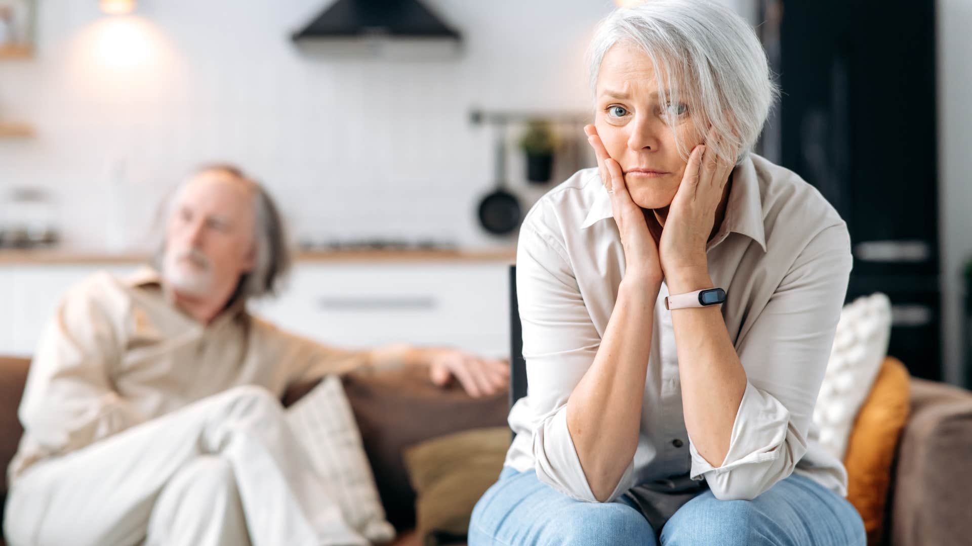 wife sitting on edge of couch away from husband