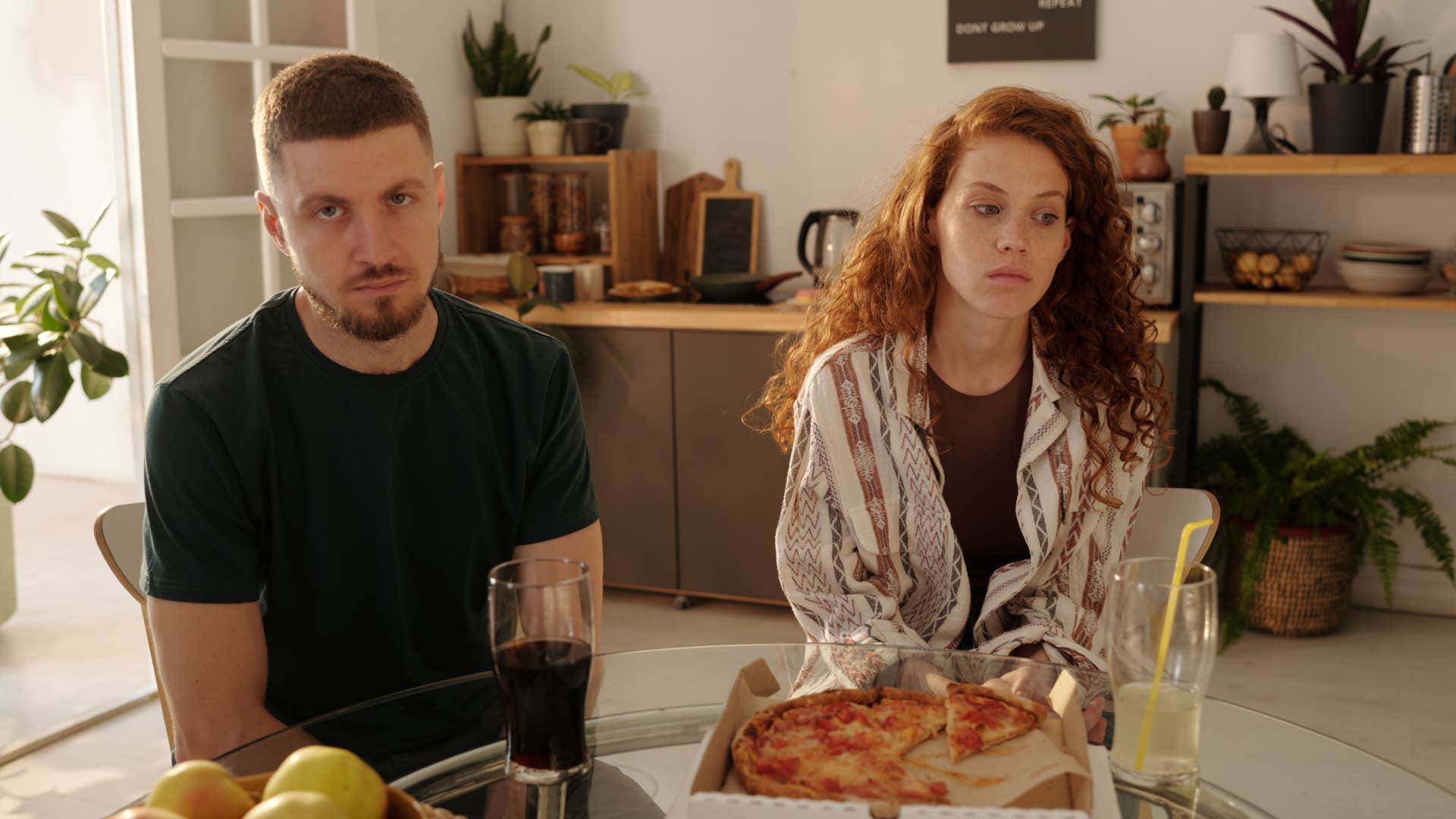 upset couple sitting at kitchen table