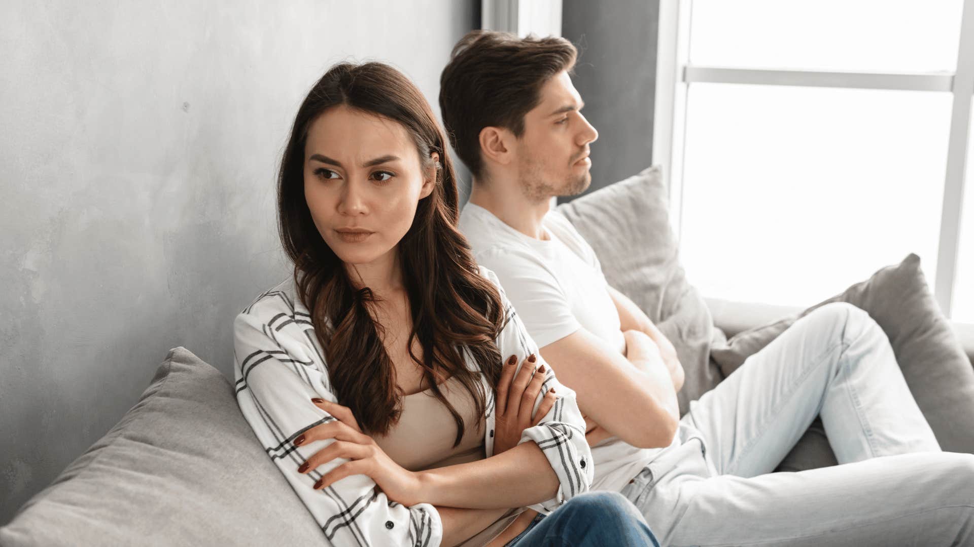 upset couple sitting on bed