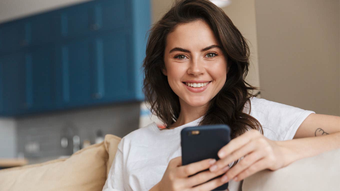 woman smiling manifesting a text message from someone