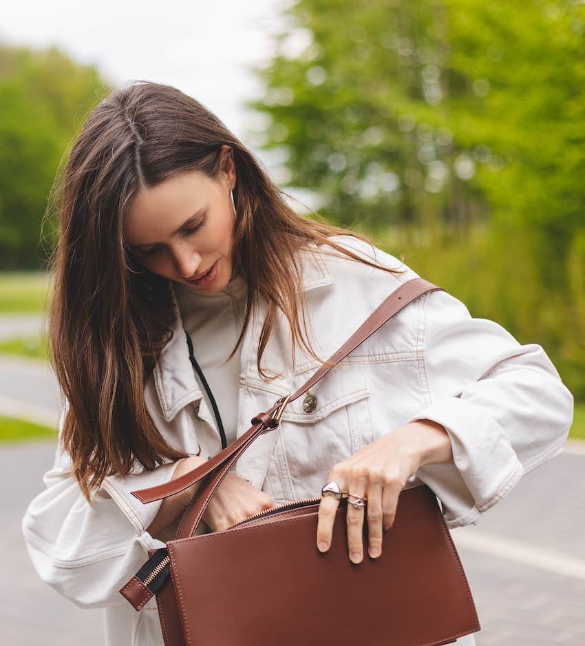 Woman looks in bag for something lost