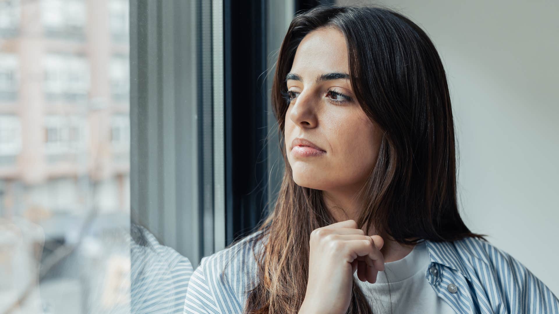 Solemn woman looking out a window