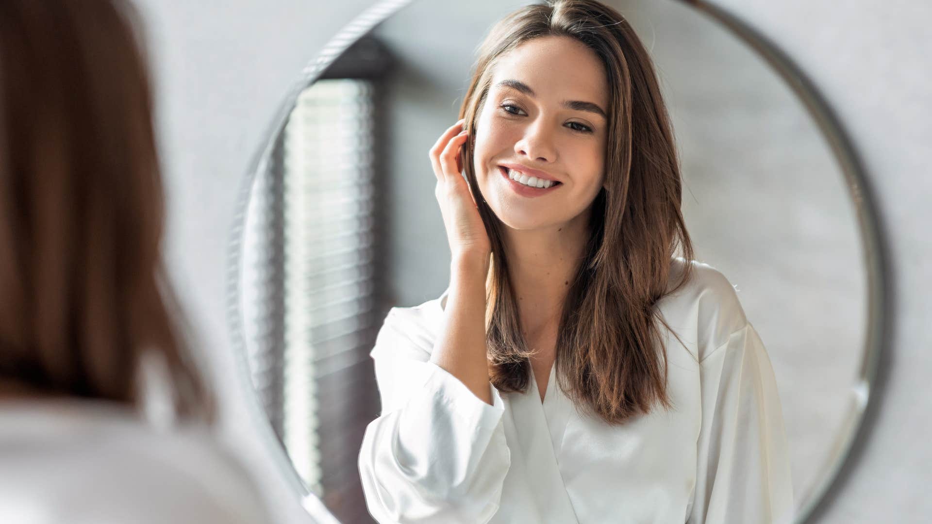 Smiling woman staring at herself in a mirror