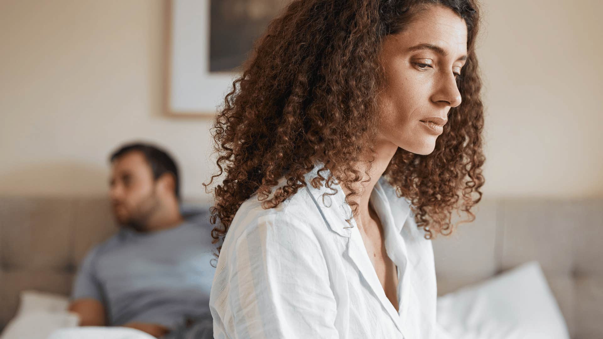 upset woman sitting on bed