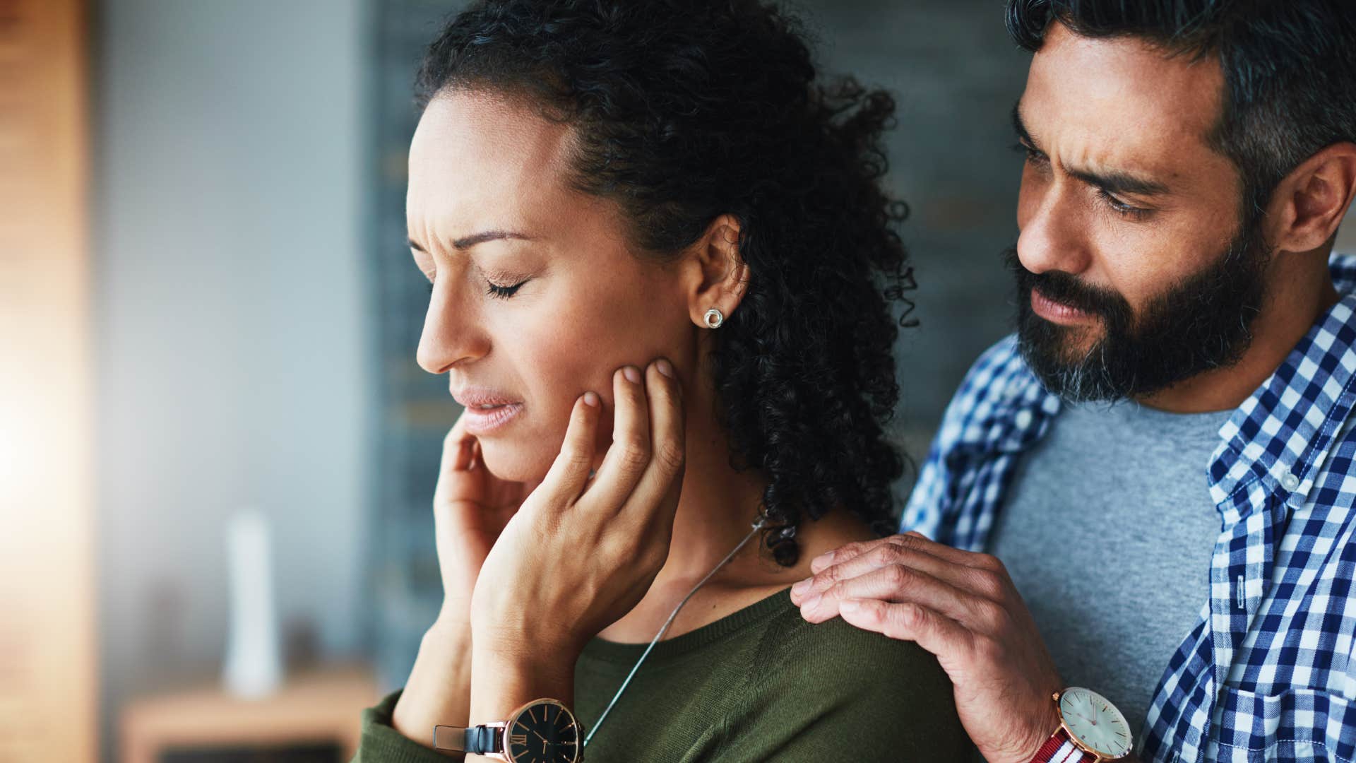 man comforting his distraught wife at home