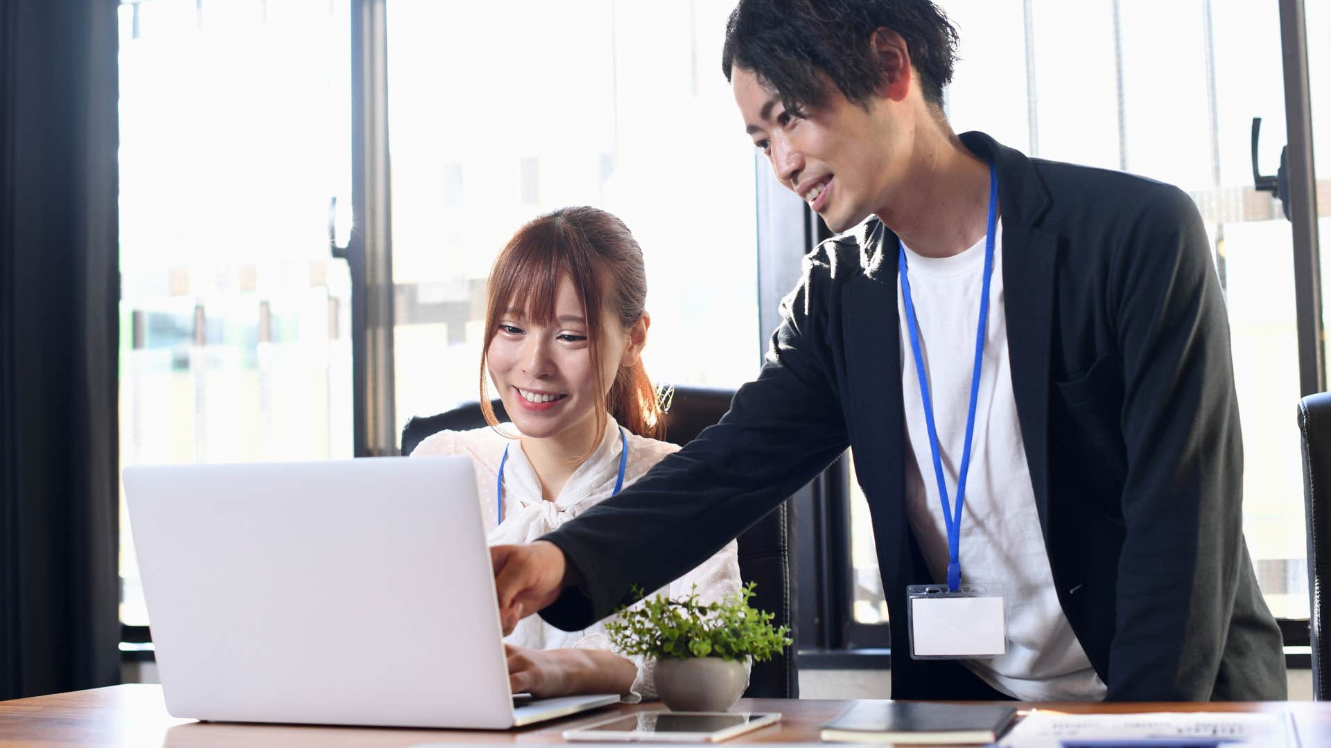 co-workers taking action on computer at work