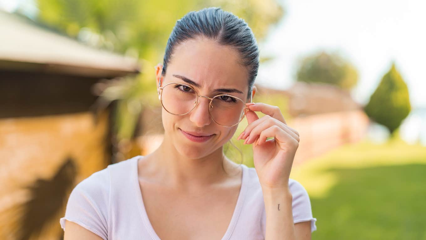 intelligent woman touching her glasses