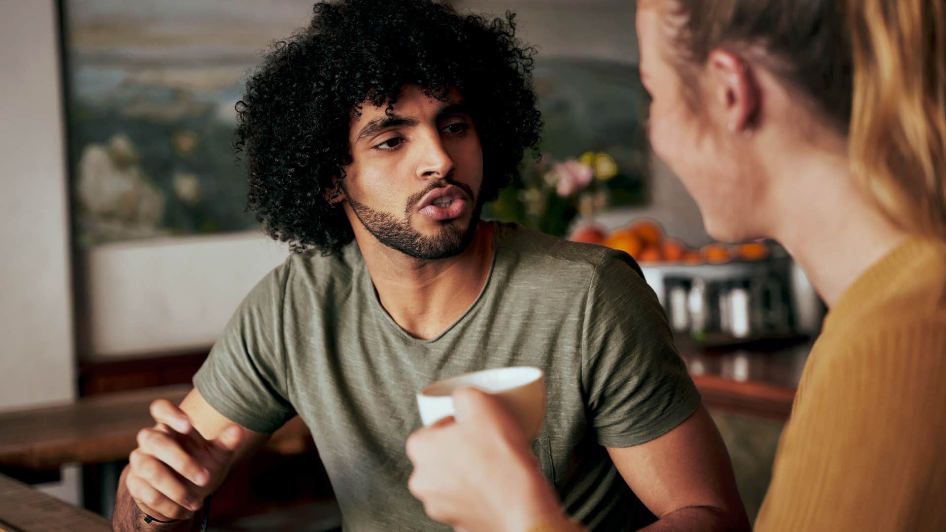 man having a conversation with a woman in a coffee shop