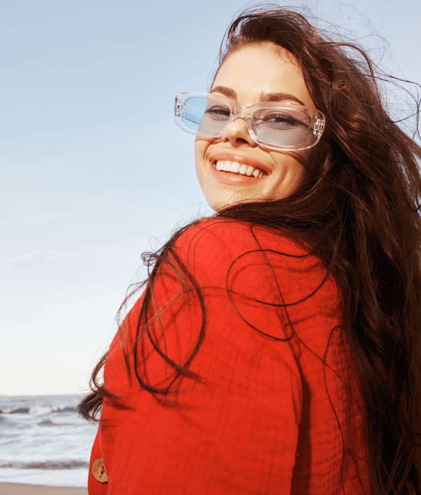 Young woman in red smiling, not lonely while seeing her shortcomings