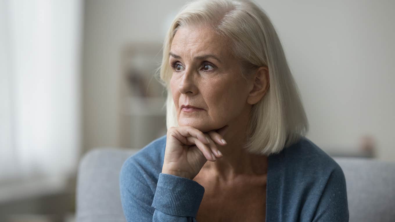 Upset boomer woman looking out of a window.