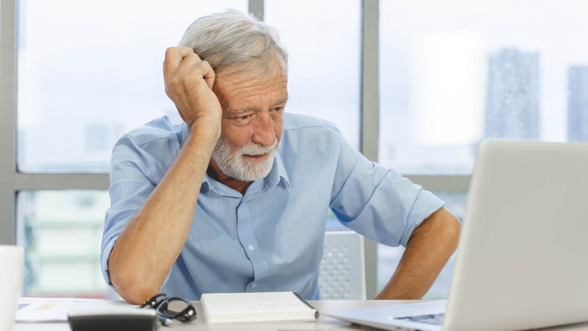 annoyed older man looking at the computer