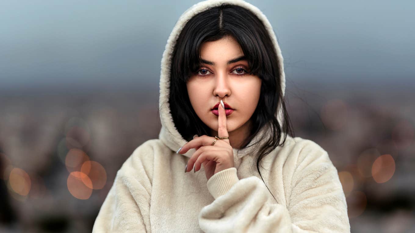 Woman in hoodie keeping secrets giving excuses for cheating