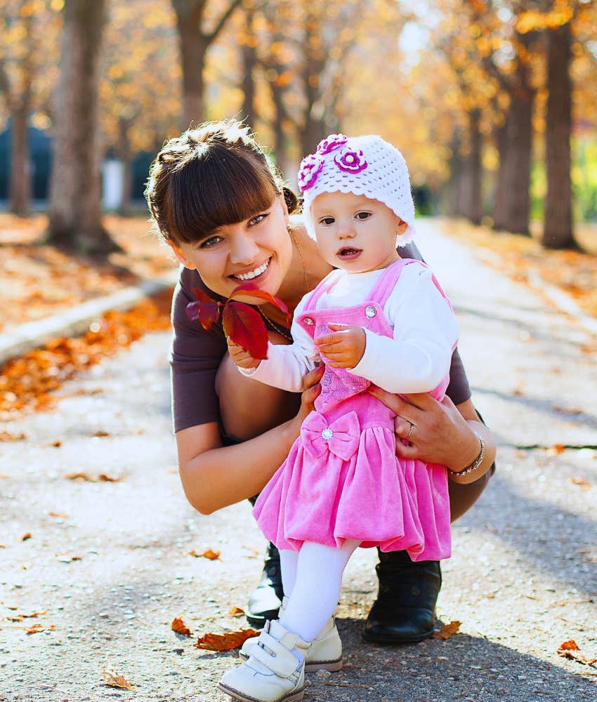 Woman with her baby in candid outdoor photo caputred by bff