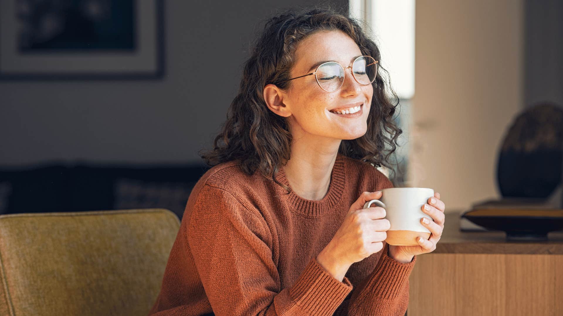 woman smiling holding a cup of coffee