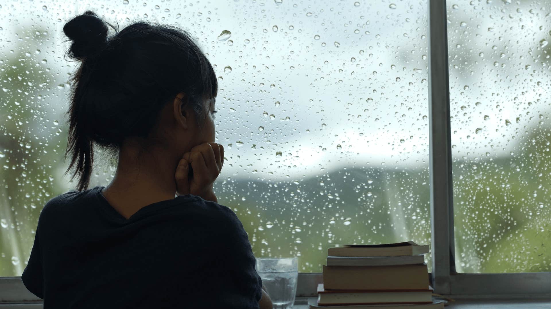 woman watching it rain outside