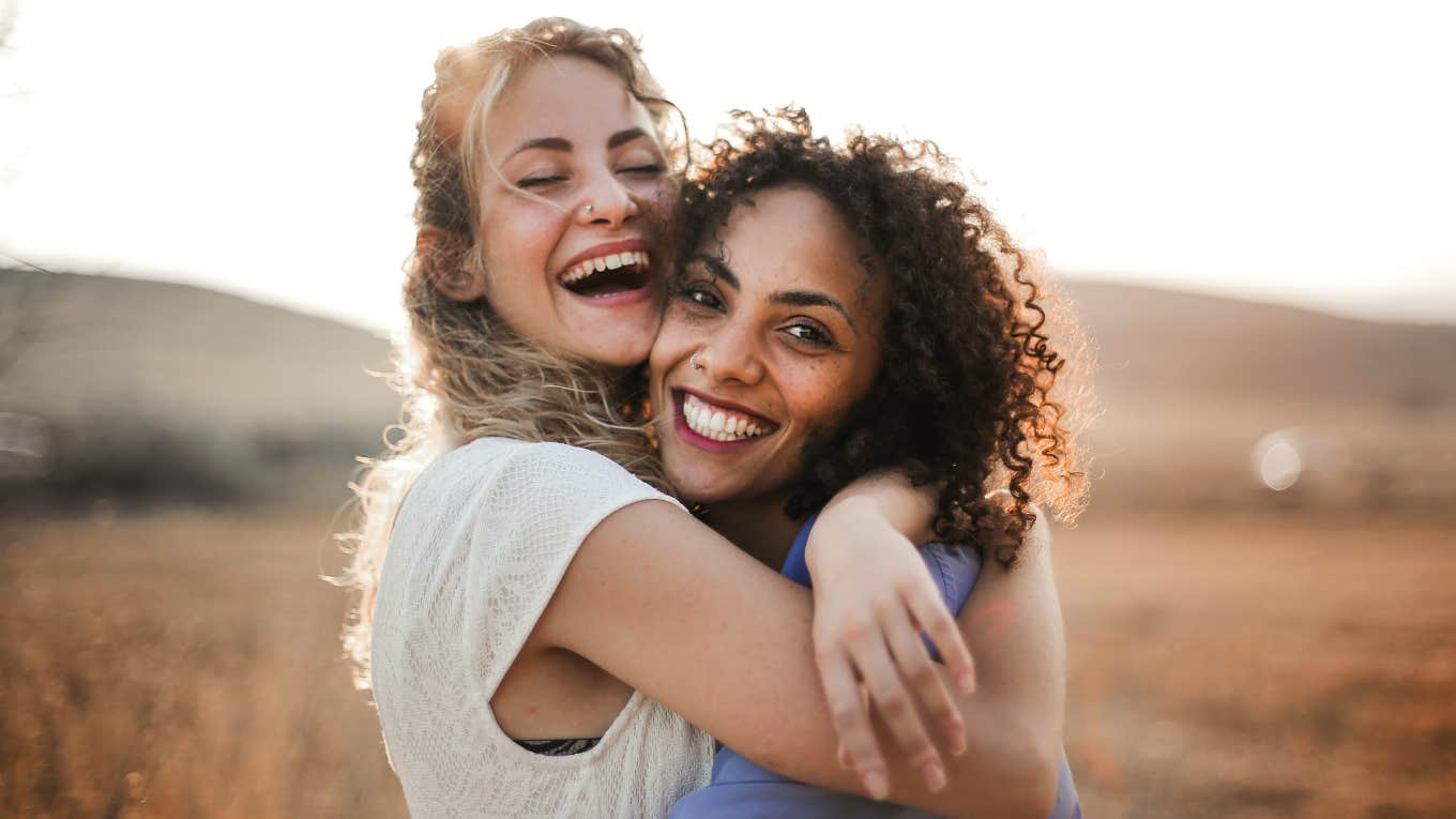 two new friends smiling and hugging