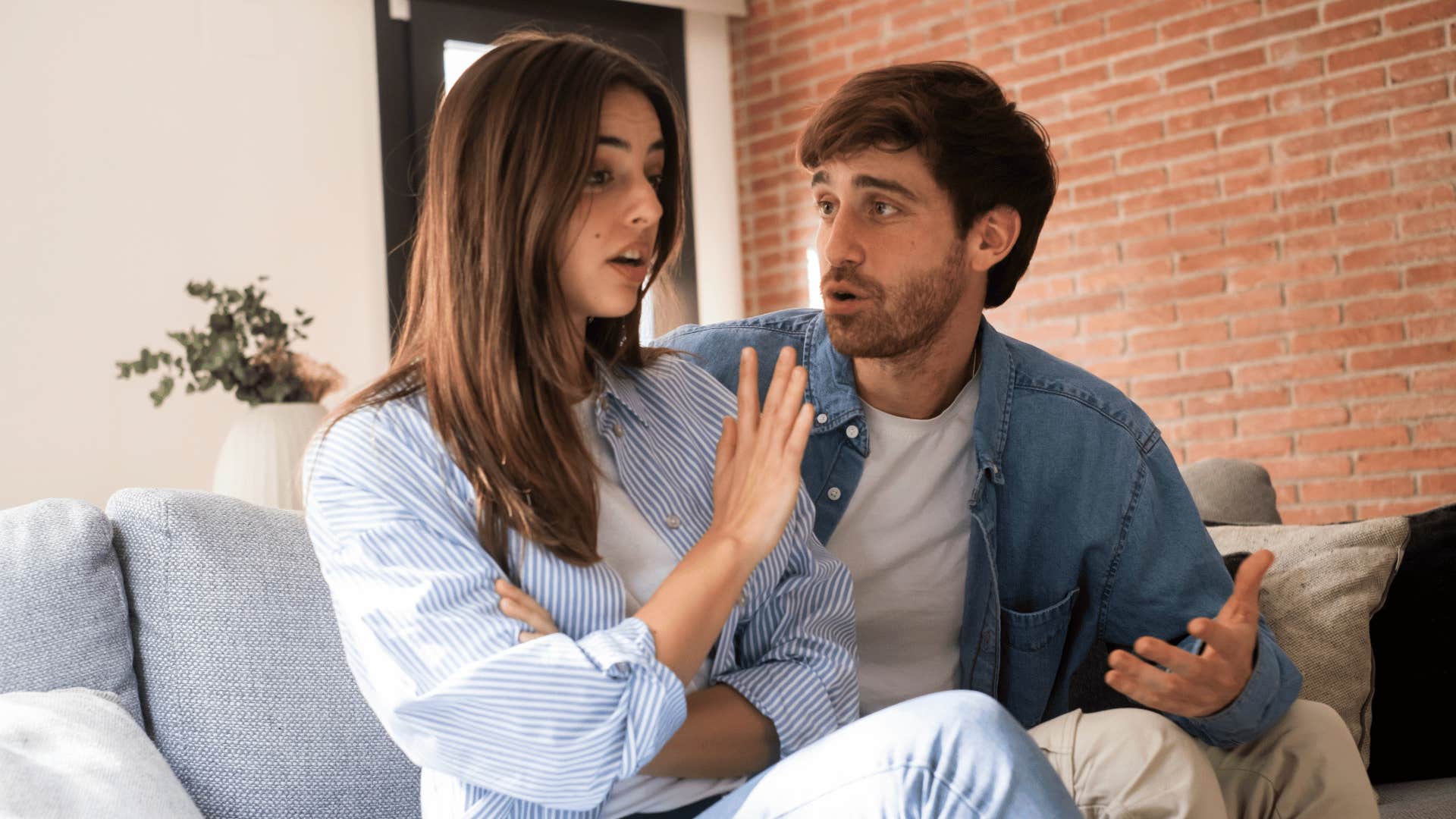 woman holding up hand annoyed at man