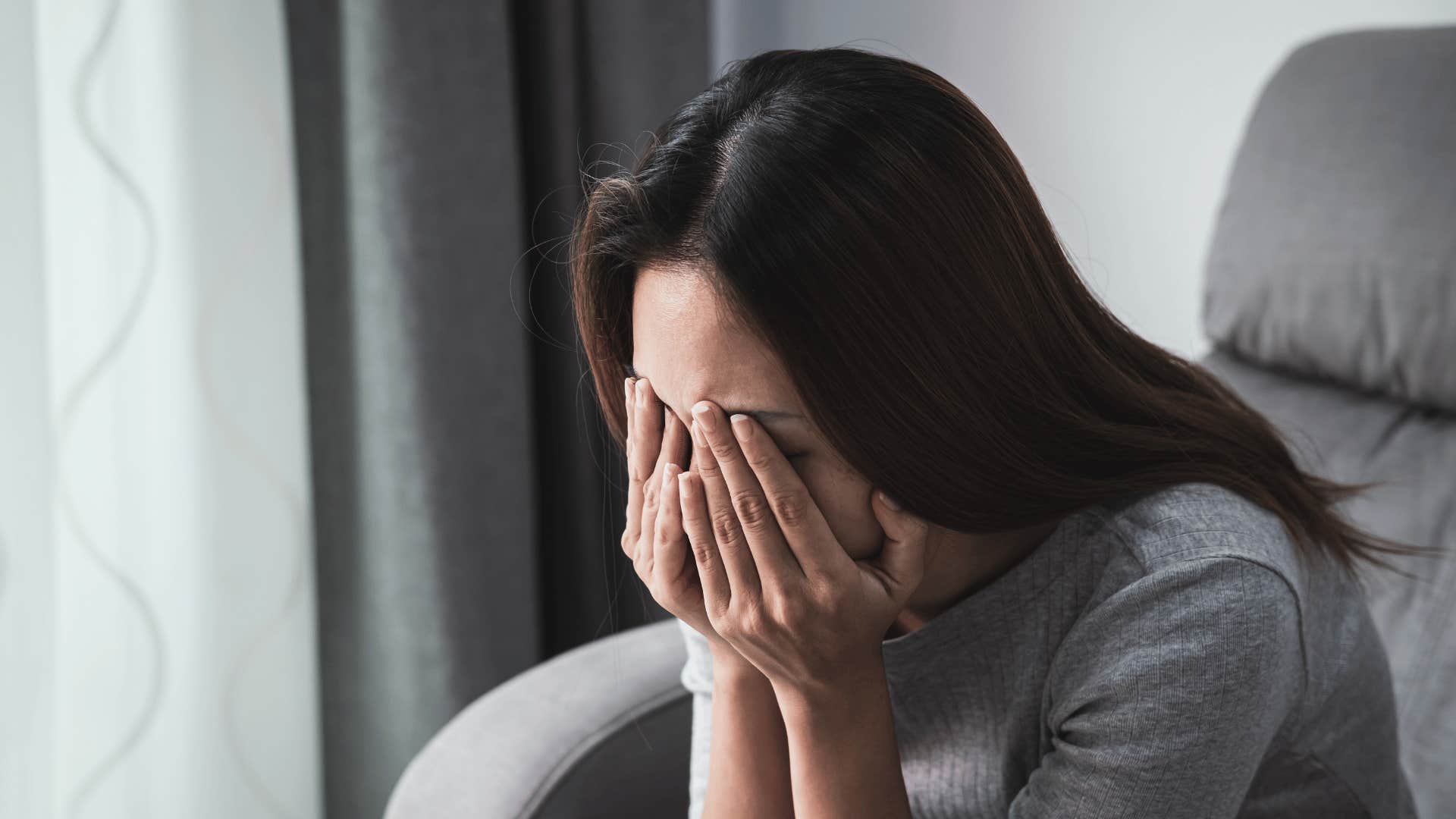 woman upset and crying in her hands 