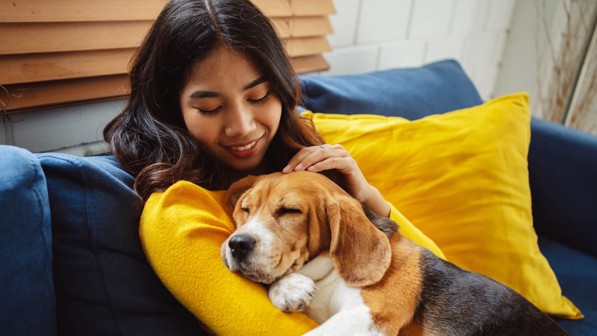 woman cuddling sleeping dog