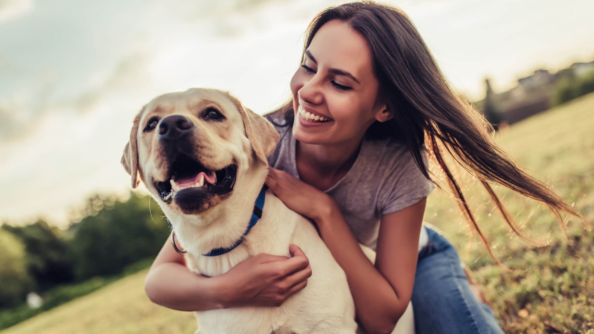 young woman with labrador outdoors.