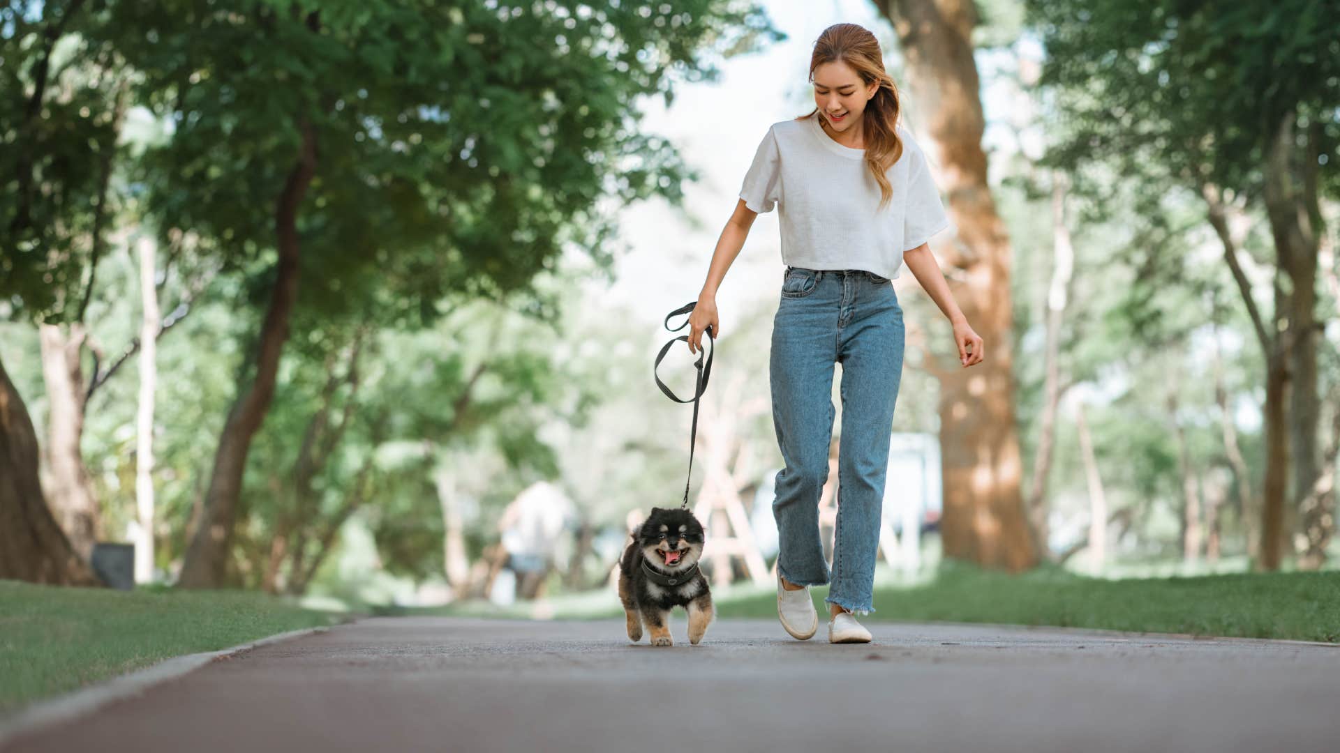 woman walking dog down street