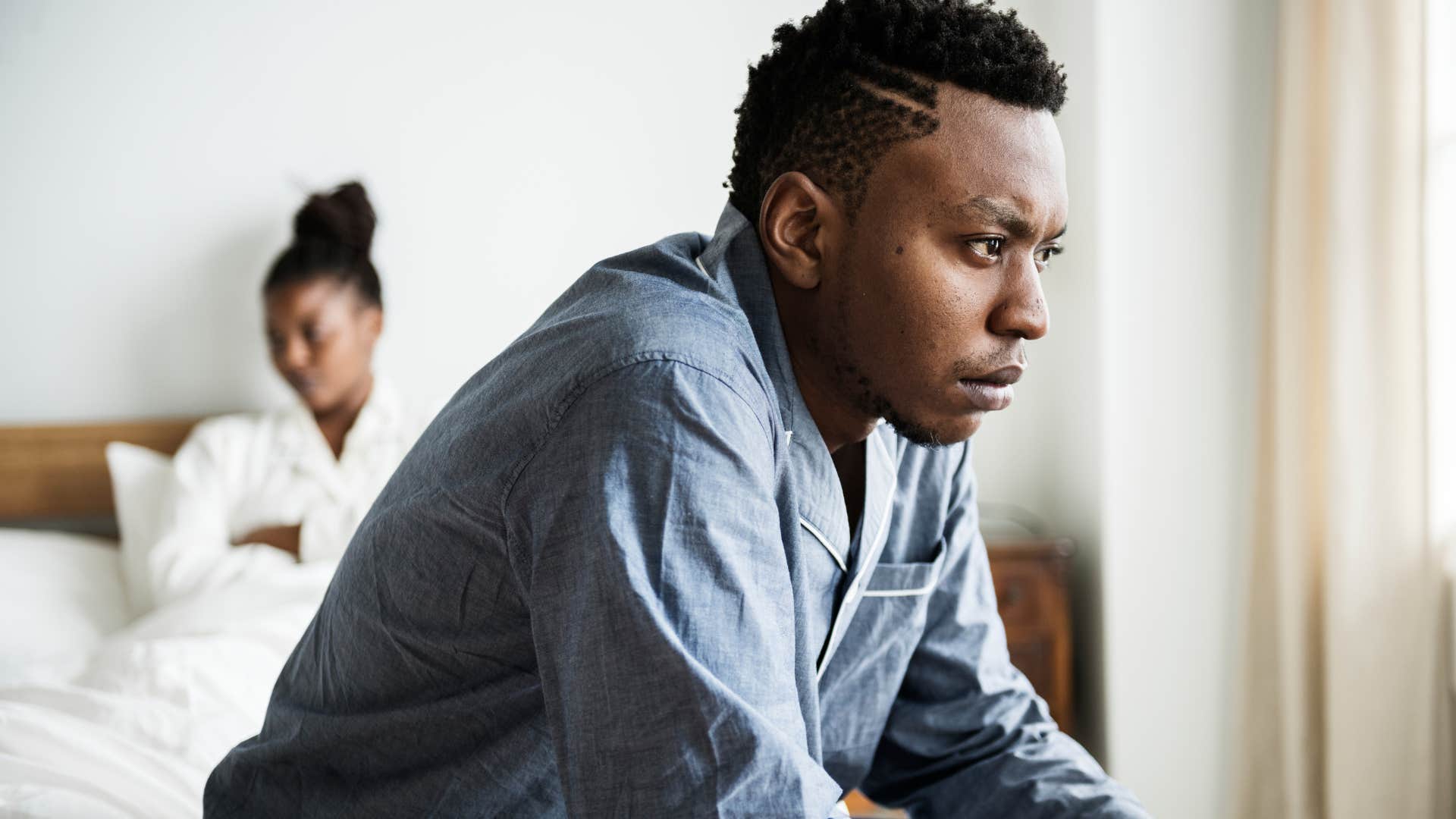 man sitting in bed thinking about his marriage