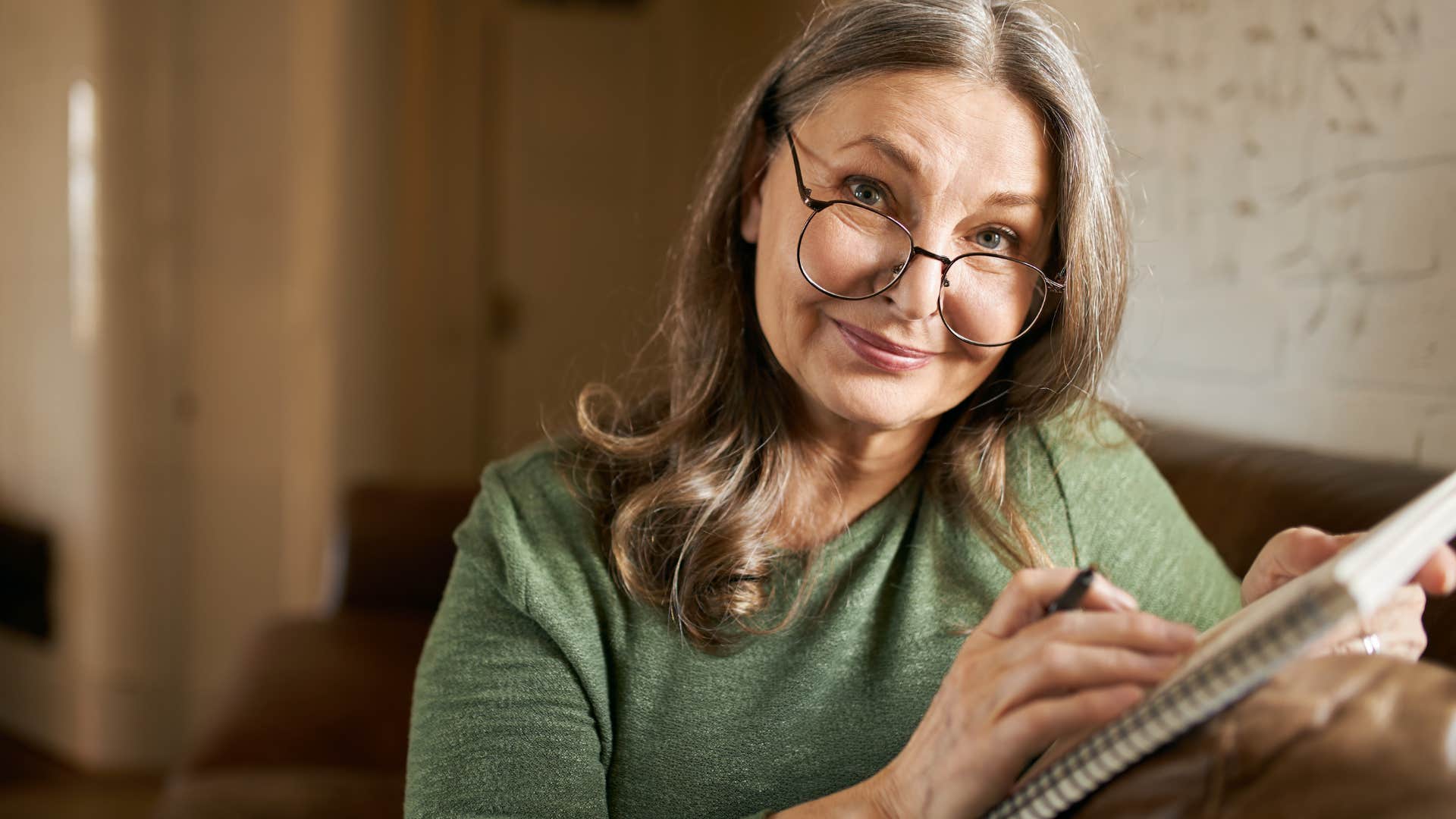 Boomer woman writing something in a notebook