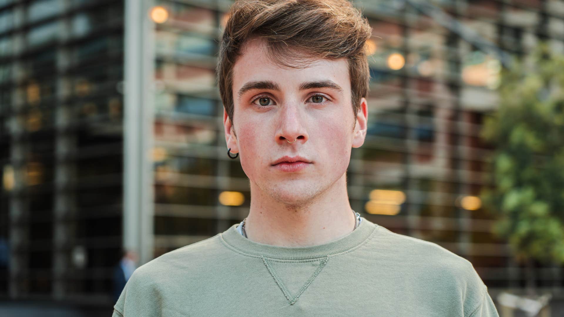 close up portrait of boy standing in front of building