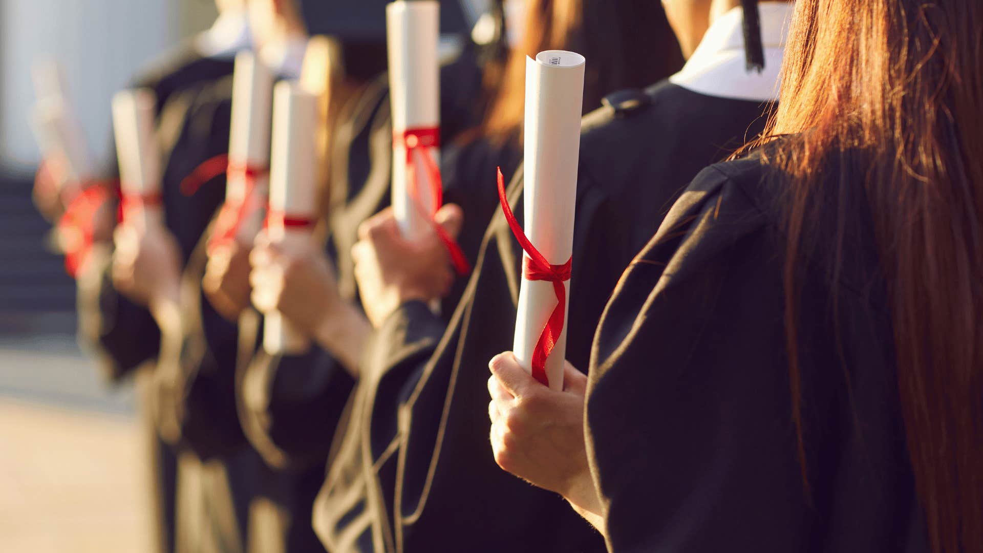 college graduates holding diplomas