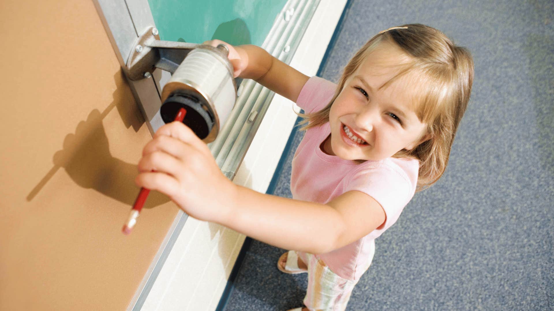 girl using pencil sharpener at school